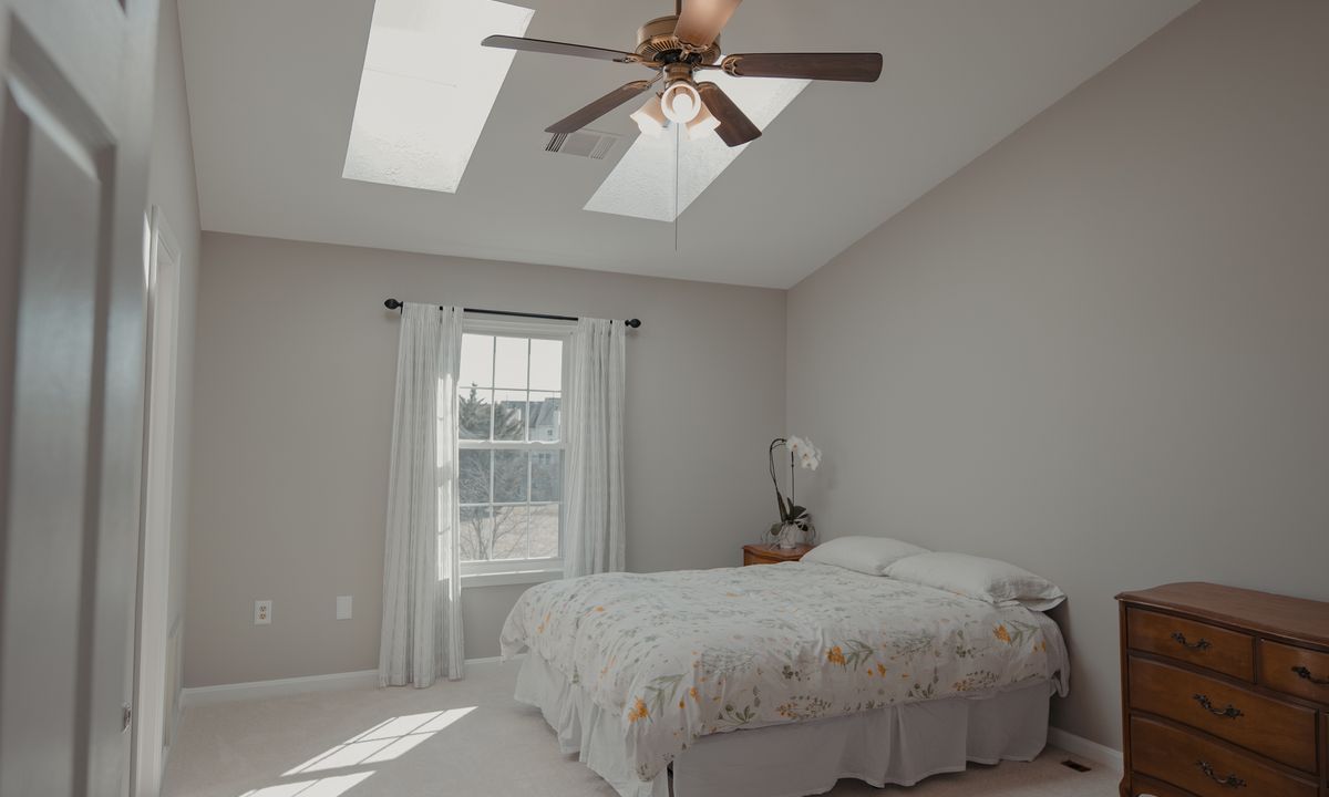 A peaceful empty bedroom with skylights and natural light