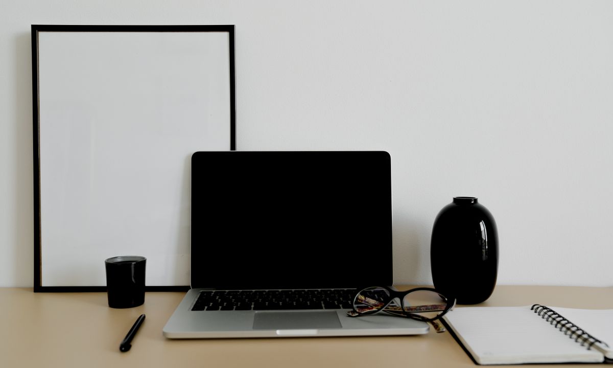 Laptop, eyeglasses and stationery arranged on a tidy desk